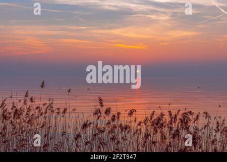 Coucher de soleil coloré incroyable pendant le brouillard sur le lac de Garde, en Italie. Paysage de Moody. Banque D'Images