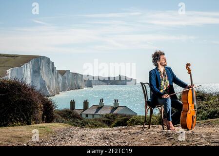 Le violoncelliste australien Anthony Albrecht, directeur du festival de musique de Lapwing, arrive dans les cottages des garde-côtes de Cuckmere Haven East Sussex. Cinq Banque D'Images