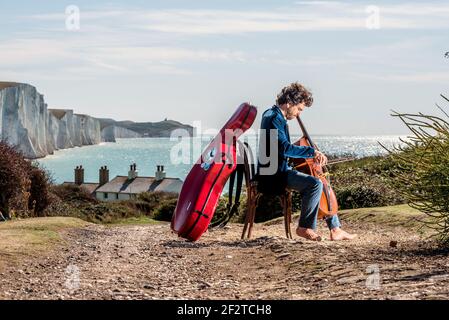 Le violoncelliste australien Anthony Albrecht, directeur du festival de musique de Lapwing, arrive dans les cottages des garde-côtes de Cuckmere Haven East Sussex. Cinq Banque D'Images