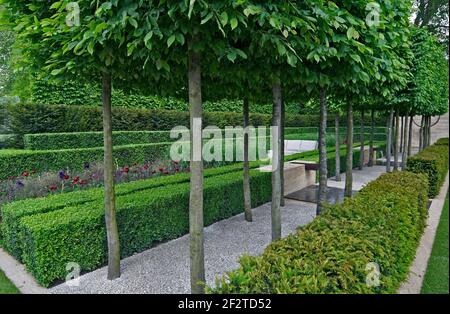 Un jardin classique avec une avenue d'if, case et charme menant à une pièce d'eau et de la sculpture Banque D'Images