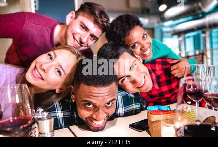 Des amis multiraciaux prennent un selfie ivre dans un restaurant de cave de vinification chic - Concept d'amitié heureuse avec les jeunes qui apprécient le temps ensemble et amuse-toi bien Banque D'Images