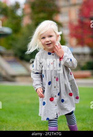 portrait d'une petite fille qui se berce et qui marche autour de chez elle une ville Banque D'Images