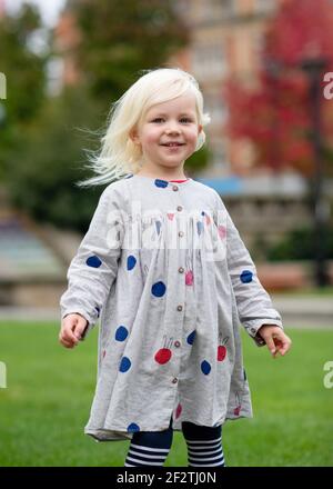 portrait d'une petite fille qui se berce et qui marche autour de chez elle une ville Banque D'Images