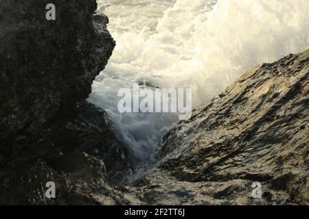 Vagues de l'Atlantique qui balaie la baie de Carlyon en lavant le sable de la plage et se brisant sur les rochers qui suivent de façon spectaculaire une tempête au large du sud Banque D'Images