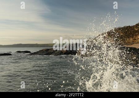 Vagues de l'Atlantique qui balaie la baie de Carlyon en lavant le sable de la plage et se brisant sur les rochers qui suivent de façon spectaculaire une tempête au large du sud Banque D'Images