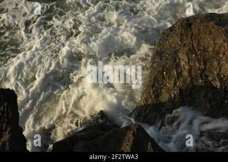 Vagues de l'Atlantique qui balaie la baie de Carlyon en lavant le sable de la plage et se brisant sur les rochers qui suivent de façon spectaculaire une tempête au large du sud Banque D'Images