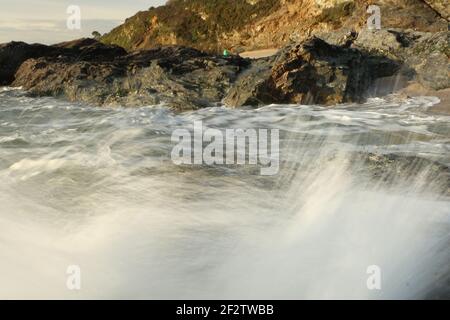 Vagues de l'Atlantique qui balaie la baie de Carlyon en lavant le sable de la plage et se brisant sur les rochers qui suivent de façon spectaculaire une tempête au large du sud Banque D'Images