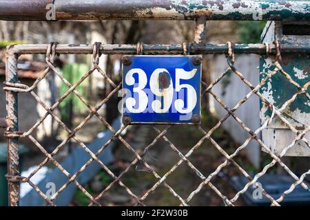 Numéro 395 nombre de maisons appartements rues. Numéro blanc de plaque en métal bleu maison numéro trois cent quatre-vingt-quinze (395) sur un mur rugueux Banque D'Images