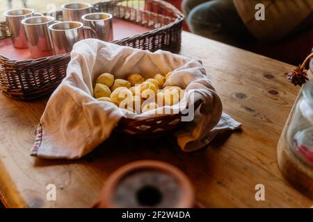 panier rempli d'en-cas de pão de queijo doré sur table avec café Banque D'Images