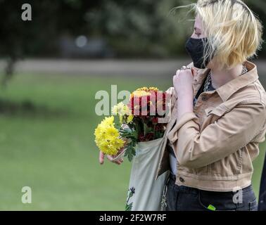 13 mars 2021. Cheltenham, Angleterre. Un membre du public tient des fleurs à la mémoire de Sarah Everard. Banque D'Images