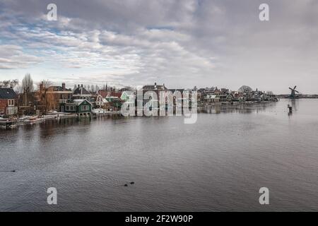 Zaan verte caractéristique des maisons avec moulin sur les rives de la rivière Zaan à Zaandijk aux Pays-Bas Banque D'Images