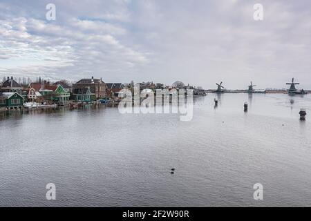 Zaan verte caractéristique des maisons avec moulin sur les rives de la rivière Zaan à Zaandijk aux Pays-Bas Banque D'Images