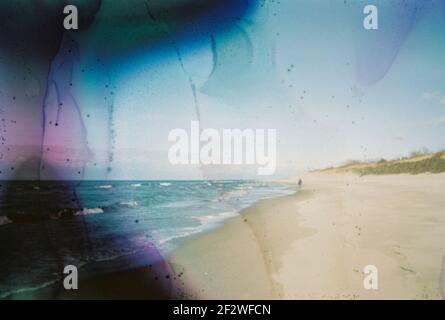 Photo endommagée et floue du bord de mer avec taches et rayures. Photo vieilli vintage. Banque D'Images