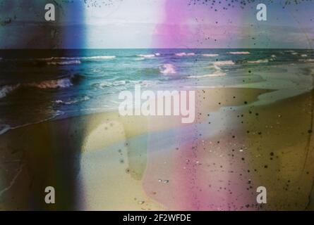 Photo endommagée et floue du bord de mer avec taches et rayures. Photo vieilli vintage. Banque D'Images