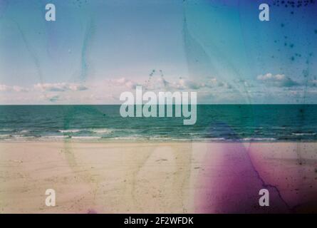 Photo endommagée et floue du bord de mer avec taches et rayures. Photo vieilli vintage. Banque D'Images