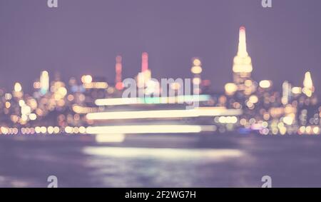 Image défocased de la ville de New York vue de l'horizon de bord de mer la nuit, couleur ton urbain résumé fond, États-Unis. Banque D'Images