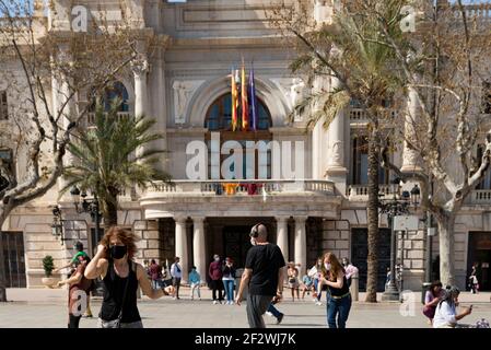 Valence, Espagne. 13 mars 2021. Les personnes portant des masques de visage dansent sur la place de l'hôtel de ville.tous les Fallas Act ont été suspendus en permanence en raison de la situation sanitaire causée par Covid19. Pour se souvenir de l'esprit des Fallas pendant la semaine suivante, un chaudron a été allumé comme un rappel sur la place de l'hôtel de ville de Valence. Crédit : SOPA Images Limited/Alamy Live News Banque D'Images