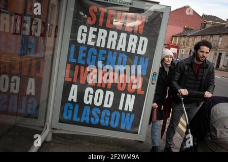 Glasgow, Royaume-Uni, le 13 mars 2021. Des affiches célébrant la victoire du titre Scottish Premiership du week-end dernier par le club de football des Rangers, leur 55e titre, et proclamant leur gestionnaire, Steven Gerrard, un « Dieu », sont apparues dans des abris de bus dans le sud de la ville. Il semblerait que la campagne d'affichage soit une campagne de guérilla, avec l'utilisation non autorisée des espaces publicitaires. Crédit photo : Jeremy Sutton-Hibbert/Alay Live News. Banque D'Images