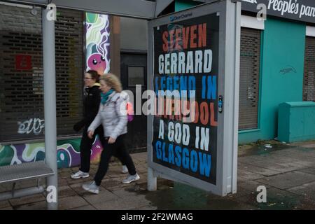 Glasgow, Royaume-Uni, le 13 mars 2021. Des affiches célébrant la victoire du titre Scottish Premiership du week-end dernier par le club de football des Rangers, leur 55e titre, et proclamant leur gestionnaire, Steven Gerrard, un « Dieu », sont apparues dans des abris de bus dans le sud de la ville. Il semblerait que la campagne d'affichage soit une campagne de guérilla, avec l'utilisation non autorisée des espaces publicitaires. Crédit photo : Jeremy Sutton-Hibbert/Alay Live News. Banque D'Images
