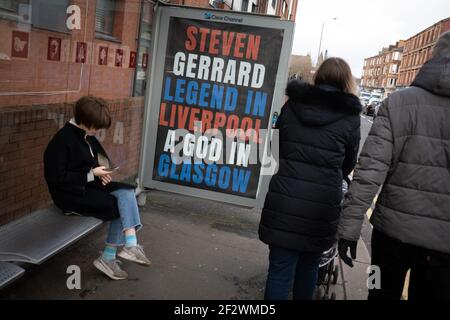 Glasgow, Royaume-Uni, le 13 mars 2021. Des affiches célébrant la victoire du titre Scottish Premiership du week-end dernier par le club de football des Rangers, leur 55e titre, et proclamant leur gestionnaire, Steven Gerrard, un « Dieu », sont apparues dans des abris de bus dans le sud de la ville. Il semblerait que la campagne d'affichage soit une campagne de guérilla, avec l'utilisation non autorisée des espaces publicitaires. Crédit photo : Jeremy Sutton-Hibbert/Alay Live News. Banque D'Images