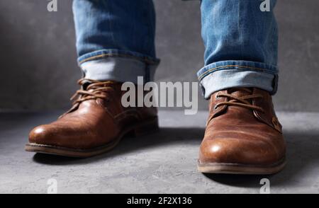 les jambes pour hommes sont en jean et les anciennes bottes de voyage en cuir vintage chaussures Banque D'Images