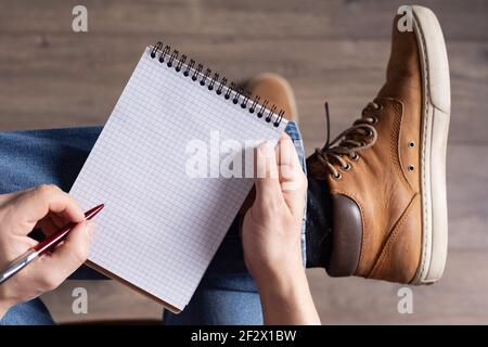 Stylo et carnet pour hommes. Étudiant homme écriture ou dessin à la main au stylo, vue de dessus Banque D'Images