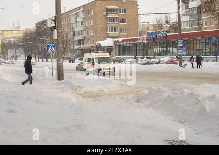 Lutsk, Ukraine - février 12,2020 : routes glissantes et trottoirs non nettoyés en hiver. Rue de ville après blizzard. Des quantités record de neige Banque D'Images