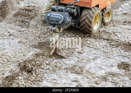 Tracteur à chenilles Terre travaillant à creuser la pose de tuyaux souterrains, installation de pose d'arroseur d'eau Banque D'Images