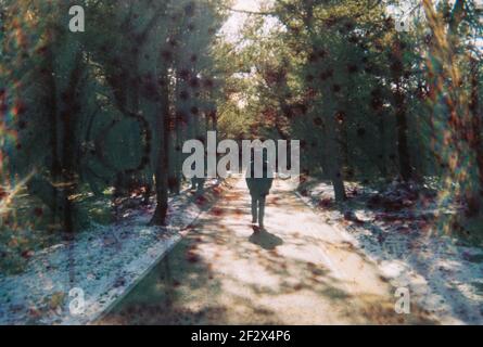 Photo d'un homme en détresse dans la forêt. Taches et rayures. Photo endommagée et floue. Banque D'Images