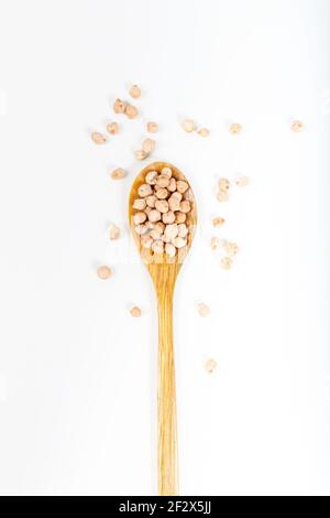 Cuillère en bois de pois chiches frais isolée sur fond blanc Banque D'Images