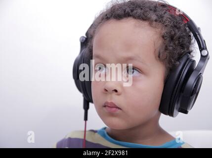 garçon avec un casque pour écouter de la musique sur fond blanc Banque D'Images