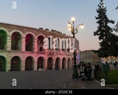 Arena di Verona, l'ancien amphithéâtre romain. La vue en soirée avec le monument éclairé et coloré par des lumières vertes, rouges et bleues. Vérone, IT Banque D'Images