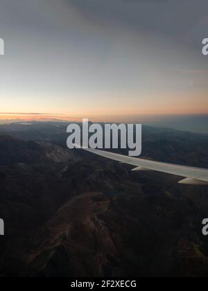 Vue panoramique sur le coucher du soleil dans les andes avec aile d'avion De l'avion siège de fenêtre atterrissage à Santiago du Chili Sud Amérique Banque D'Images