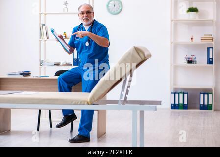 Médecin senior prenant des notes dans la clinique Banque D'Images