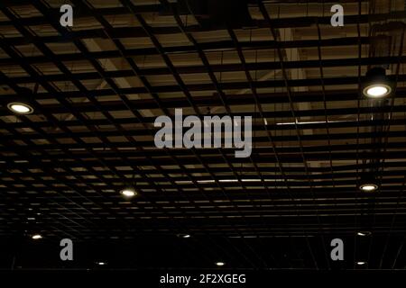 Lumières et système de ventilation en longue ligne sur plafond du bâtiment industriel bureau sombre, Hall d'exposition d'un plafond. Banque D'Images