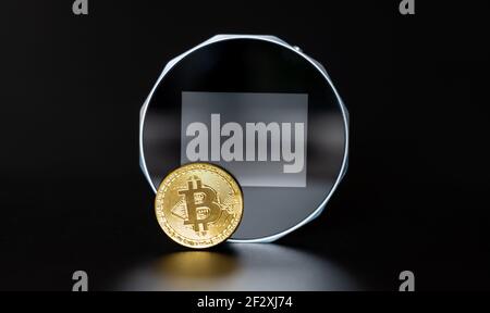 Un Bitcoin devant un portefeuille numérique. Banque D'Images