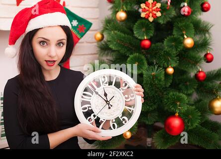 Nouvelle année 2017. Cinq à douze. Belle jeune femme avec grande horloge de décoration et de partie Banque D'Images