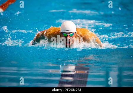 Le champion olympique Michael Phelps nage le papillon dans une course. Banque D'Images