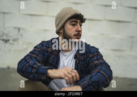 Un homme espagnol frais habillé à la légère sur un fond de mur flou Banque D'Images