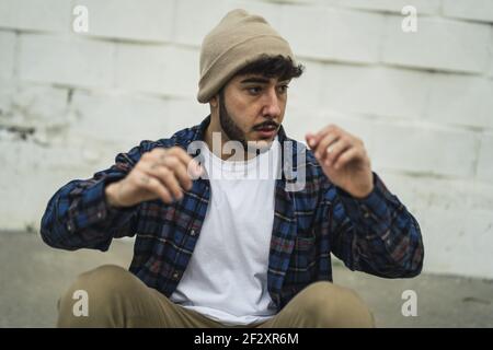 Un homme espagnol frais habillé à la légère sur un fond de mur flou Banque D'Images