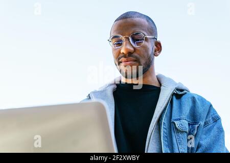 D'un membre de l'équipe afro-américain à distance ordinateur portable installé en ville Banque D'Images
