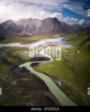 Vue incroyable de la boucle de rivière bleu curvy en streaming sur brut Terrain vallonné recouvert d'une végétation luxuriante et abondante en Islande Banque D'Images