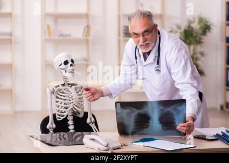 Squelette de cigarette dépendance patient visitant le vieux médecin mâle Banque D'Images
