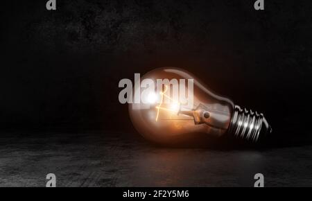 Ampoule avec lumière blanche et chaude orange sur fond de pièce sombre et espace de copie. Concept de symbole d'invention conceptuelle et créative. Illustration 3D ren Banque D'Images