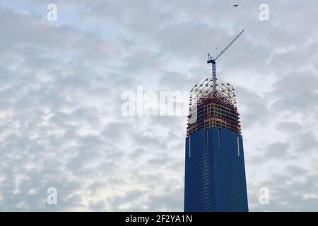 « The Exchange 106 » en construction : un gratte-ciel presque terminé avec une grue sur le dessus et avec seulement la couronne de verre à construire Banque D'Images