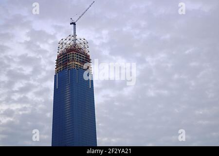 « The Exchange 106 » en construction : un gratte-ciel presque terminé avec une grue sur le dessus et avec seulement la couronne de verre à construire Banque D'Images