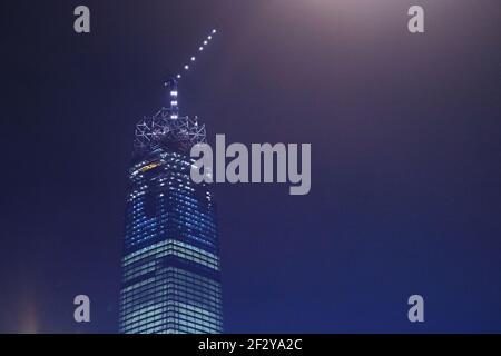 The Exchange 106' en construction la nuit un gratte-ciel presque terminé avec une grue sur le dessus et avec seulement la couronne de verre à construire: Banque D'Images