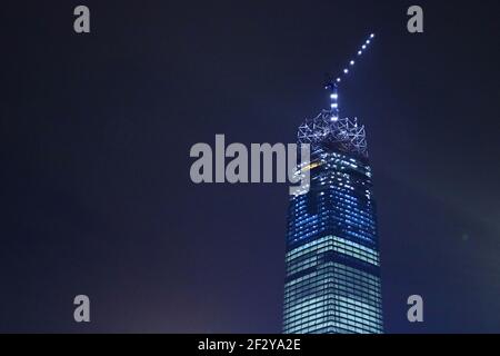 The Exchange 106' en construction la nuit un gratte-ciel presque terminé avec une grue sur le dessus et avec seulement la couronne de verre à construire: Banque D'Images