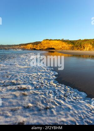 Wave roule sur le sable à Caves Beach au sud de Newcastle - Nouvelle-Galles du Sud Australie Banque D'Images