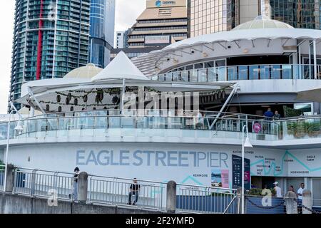 Brisbane, Queensland, Australie - Mars 2021 : restaurants sur les rives de la rivière avec des blocs de bureaux de la ville en arrière-plan Banque D'Images